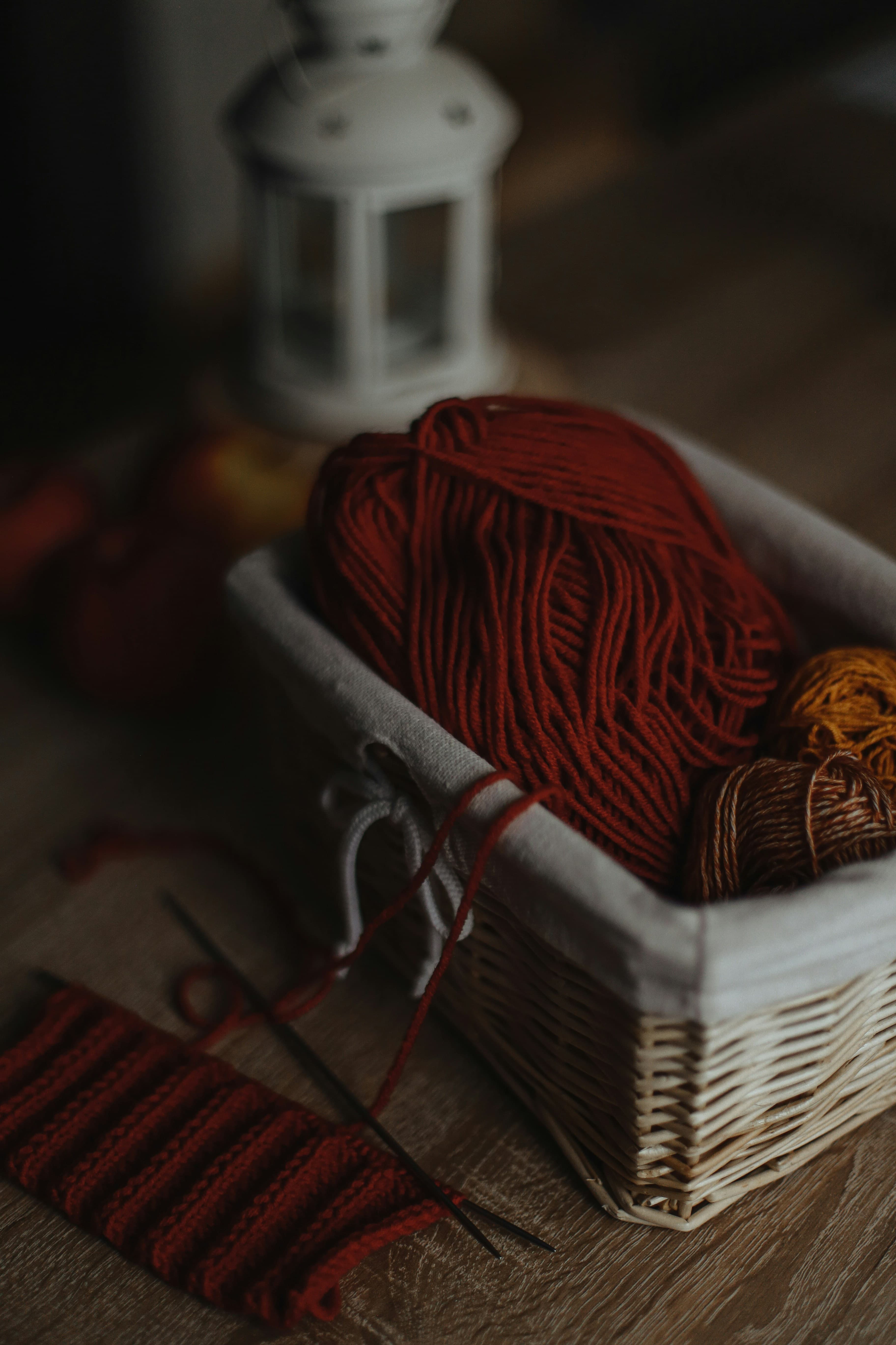A basket of yarn and scissors on a wooden table